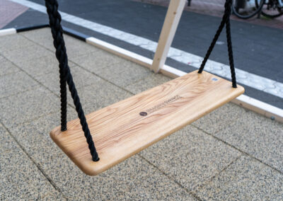 Holzschaukelbrett mit schwarzen dicken Seilen