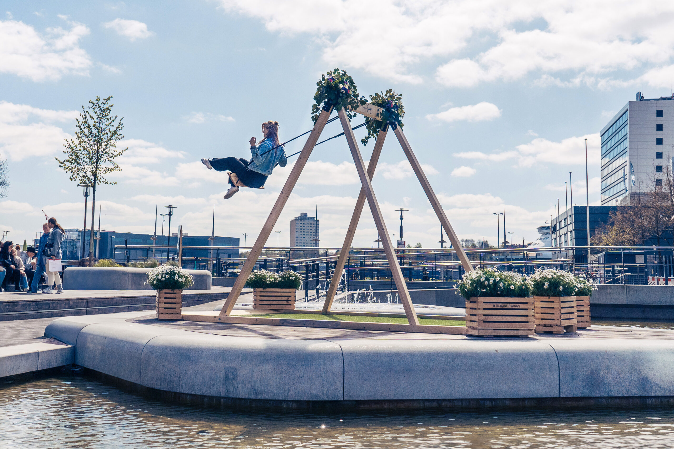 Imagine-Swings_Pop-up-Schaukel_Kiel-Innenstadt-7-ohne-Schild Schaukel mit schaukelnder Frau in der Stadt