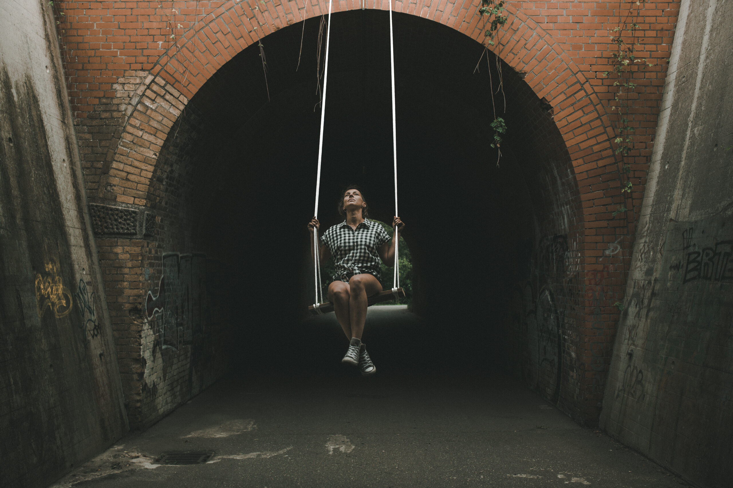 Frau schaukelt aus einem dunklen Tunnel heraus